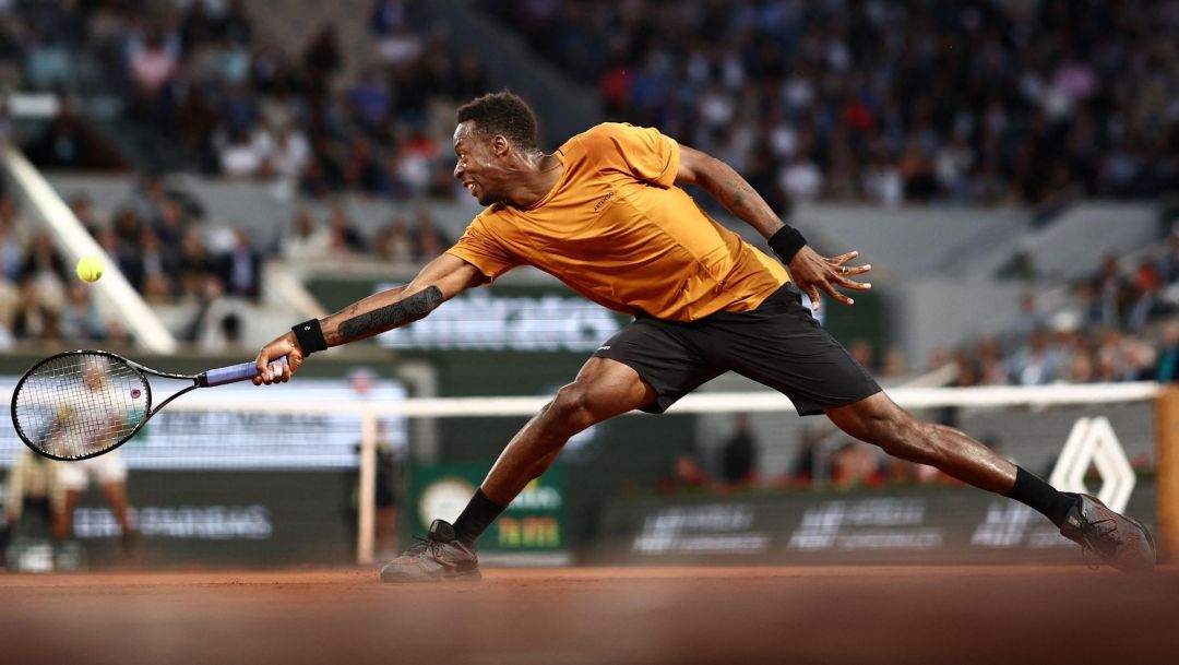 TOPSHOT - France's Gael Monfils plays a backhand return to Argentina's Sebastian Baez during their men's singles match on day three of the Roland-Garros Open tennis tournament at the Court Philippe-Chatrier in Paris on May 30, 2023. (Photo by Anne-Christine POUJOULAT / AFP)