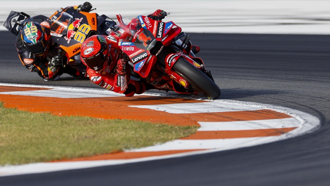 Italian rider Francesco Bagnaia of the Ducati Lenovo Team steers his motorcycle followed by South African rider Brad Binder of the Red Bull KTM Factory Racing during the MotoGP race of the Valencia Motorcycle Grand Prix, the last race of the season, at the Ricardo Tormo circuit in Cheste near Valencia, Spain, Sunday, Nov. 26, 2023. (AP Photo/Alberto Saiz)