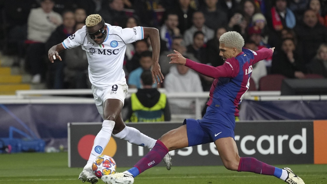 Napoli's Victor Osimhen, left, is challenged by Barcelona's Ronald Araujo during the Champions League, round of 16, second leg soccer match between Barcelona and SSC Napoli at the Olympic Lluis Companys stadium in Barcelona, Spain, Tuesday, March 12, 2024. (AP Photo/Emilio Morenatti)