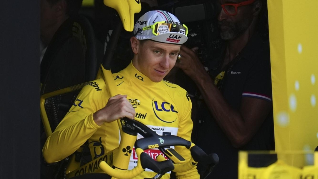 Tour de France winner Slovenia's Tadej Pogacar, wearing the overall leader's yellow jersey, walk to the podium after the twenty-first stage of the Tour de France cycling race, an individual time trial over 33.7 kilometers (20.9 miles) with start in Monaco and finish in Nice, France, Sunday, July 21, 2024. (AP Photo/Daniel Cole)