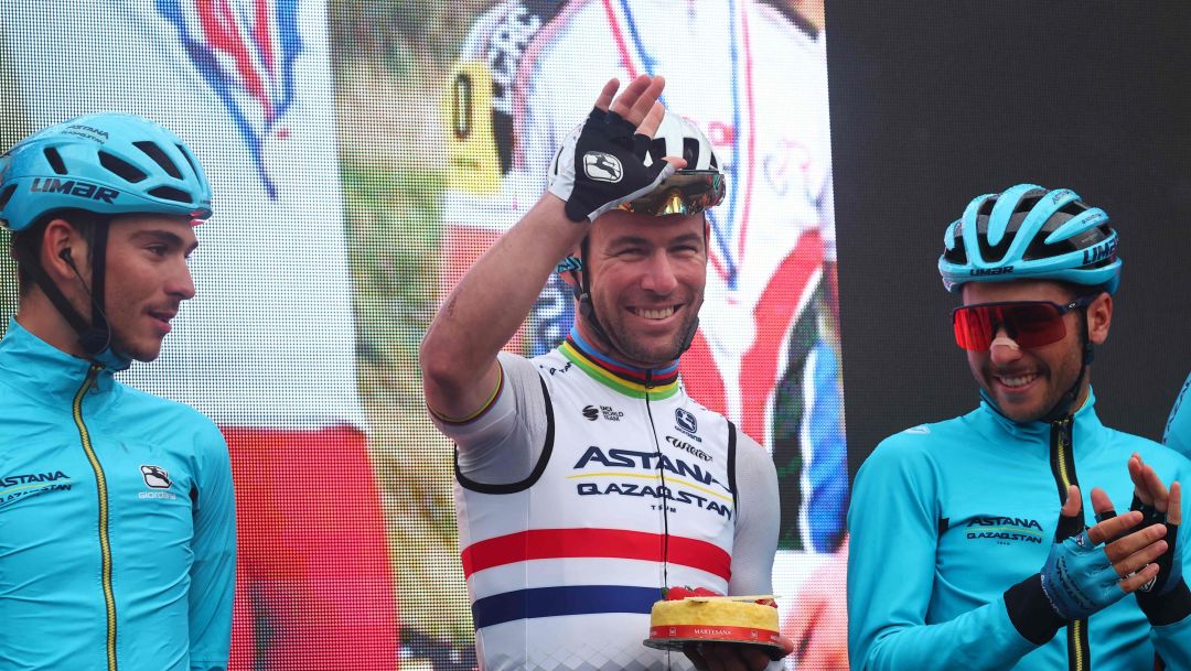 Astana Qazaqstan Team's British rider Mark Cavendish (C), holding a cake to celebrate his 38th birthday, waves during the presenattion of the teams prior to the fifteenth stage of the Giro d'Italia 2023 cycling race, 195 km between Seregno and Bergamo, on May 21, 2023. (Photo by Luca Bettini / AFP)