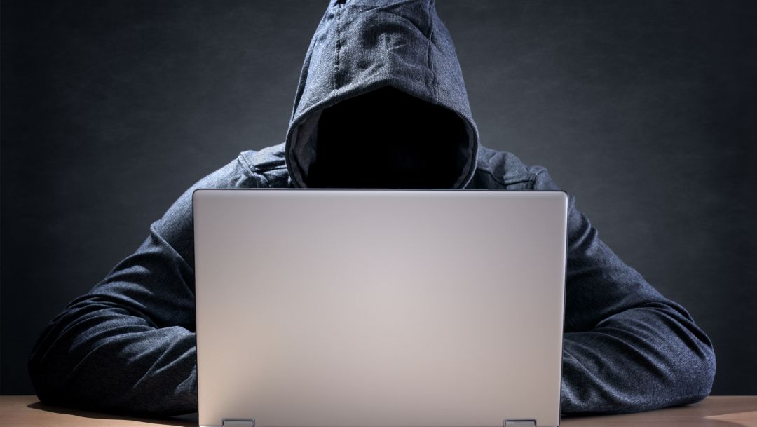 Computer hacker stealing data from a laptop concept for network security, identity theft and computer crime