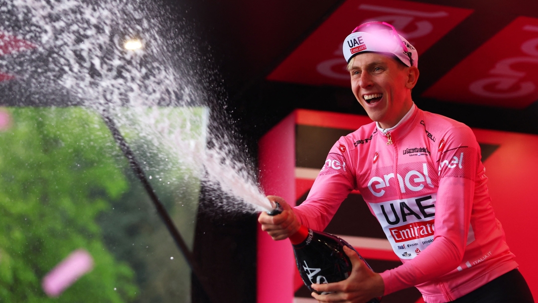 Team UAE's Slovenian rider Tadej Pogacar celebrates on the podium his overall leader's pink jersey, after he won the 2nd stage of the 107th Giro d'Italia cycling race, 161km between San Francesco al Campo and Sanctuary of Oropa (Biella), on May 5, 2024 in Biella. (Photo by Luca Bettini / AFP)