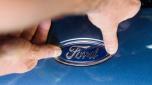 Ein Ford-Mitarbeiter bringt in der Bumper-Vormontage das Ford-Logo an.