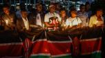 People hold a national flag of Kenya as they attend a candle light vigil for the late Kenyan marathon runner Kelvin Kiptum in Nairobi, on February 22, 2024. Kenya's world-record holding marathon runner Kelvin Kiptum, a prodigy who ran three of the seven fastest marathons in history and was ranked first among the world's men's marathon runners, tragically died in a car crash in Kenya on February 11, 2024 at the age of 24, in an accident that shocked the world and plunged the East African nation into mourning. (Photo by SIMON MAINA / AFP)