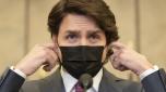 Canadian Prime Minister Justin Trudeau removes his mask as he arrives at a news conference to announce the Emergencies Act will be invoked to deal with protests, Monday, Feb. 14, 2022 in Ottawa. Trudeau says he has invoked the act to bring to an end antigovernment blockades he describes as illegal. (Adrian Wyld/The Canadian Press via AP)