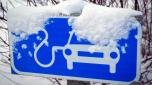 A sign for charging electric cars is covered in snow in Tallinn, Estonia, Saturday, Feb. 11, 2023. Many electric vehicle batteries lose power when it's very cold. It's something that's long been known by engineers but thousands of people are confronting the issue now if they own an electric car and have to make a longer trip when temperatures dip. (AP Photo/Sergei Grits)