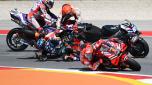Honda Spanish rider Marc Marquez (C TOP) crashes with Aprilia Portuguese rider Miguel Oliveira (C BOTTOM) as Ducati Italian rider Francesco Bagnaia (R) rides past during the MotoGP race of the Portuguese Grand Prix at the Algarve International Circuit in Portimao, on March 26, 2023. (Photo by PATRICIA DE MELO MOREIRA / AFP)