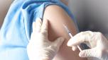 Vaccination healthcare concept. Hands of doctor or nurse in medical gloves injecting a shot of vaccine to a man patient.