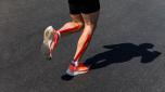 male runner legs on calf kinesio taping run marathon