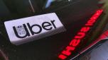 FILE - An Uber sign is displayed inside a car in Glenview, Ill., Saturday, Dec. 17, 2022.  Consumers will pay more for that airline flight or willing to fork out more for a ride on Uber during rush hour. But a big shopper backlash to media reports this past week that fast-food chain Wendy?s had plans to increase prices during the busiest time at its restaurants clearly showed that consumers don?t want basic food items like hamburgers and shakes going up and down(AP Photo/Nam Y. Huh, File)