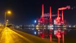 The power station at the Volkswagen AG plant is illuminated in red and reflected on the surface of the Mittelland Canal, in Wolfsburg, Germany, on Saturday, Nov. 30, 2024, as the so-called peace obligation, during which no strikes are permitted, expires at the company at midnight Saturday. (Michael Matthey/dpa via AP)