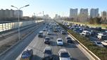 Vehicles drive in Beijing on December 23, 2024. (Photo by ADEK BERRY / AFP)