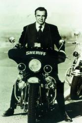 L’attore durante le riprese di «Una cascata di diamanti» su una Moto Guzzi V7 Ambassador, veicolo in dotazione a diversi corpi di Polizia negli Usa