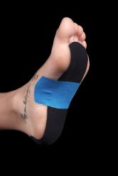 Close up showing the foot of a young woman with kinesiotape under it.