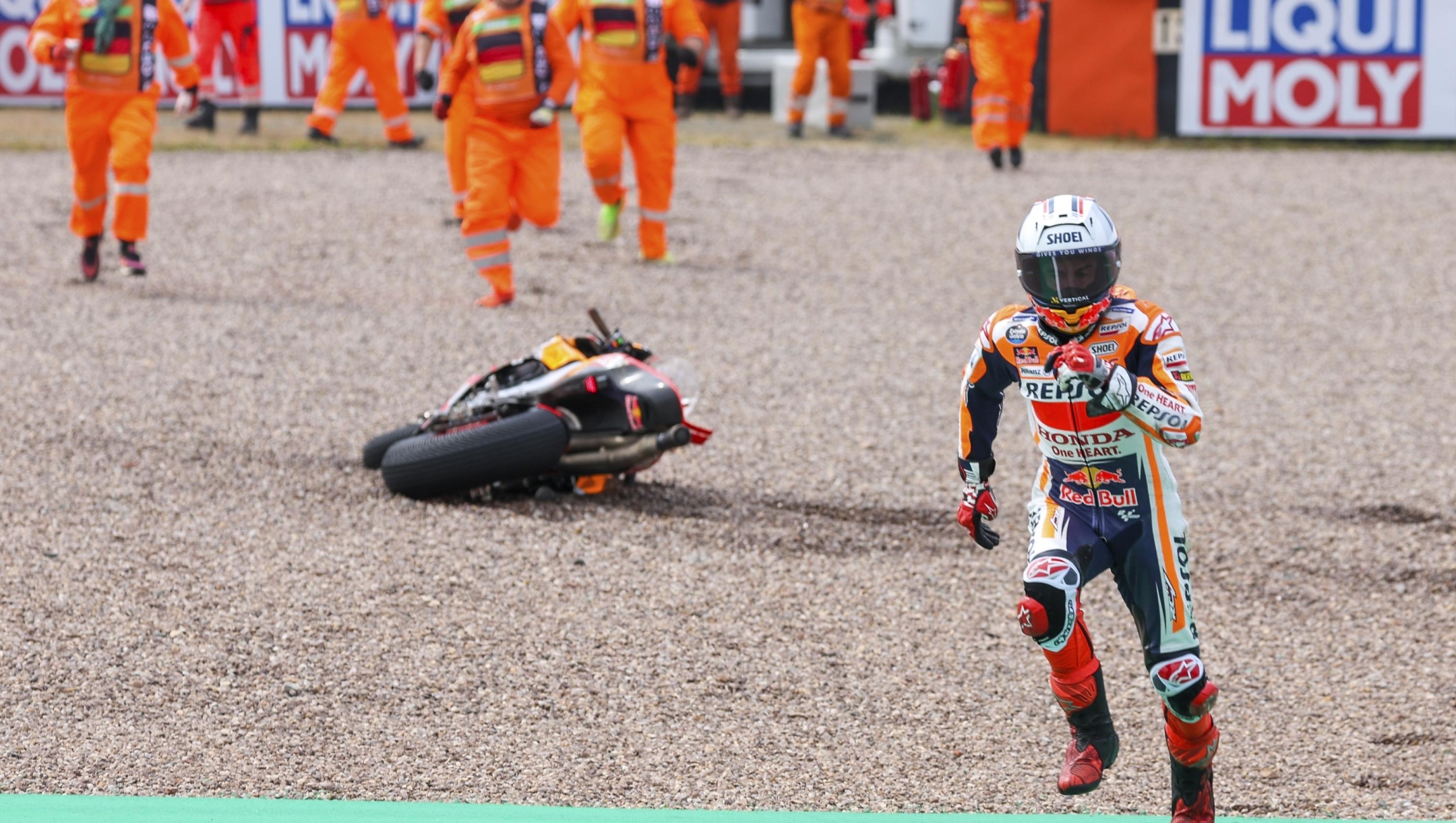 Marc Marquez from Spain runs to get a second bike after falling on his Repsol Honda during qualifying practice for the German Grand Prix at the Sachsenring in  Hohenstein-Ernstthal, Germany, Saturday, June 17, 2023. (Jan Woitas//dpa via AP)