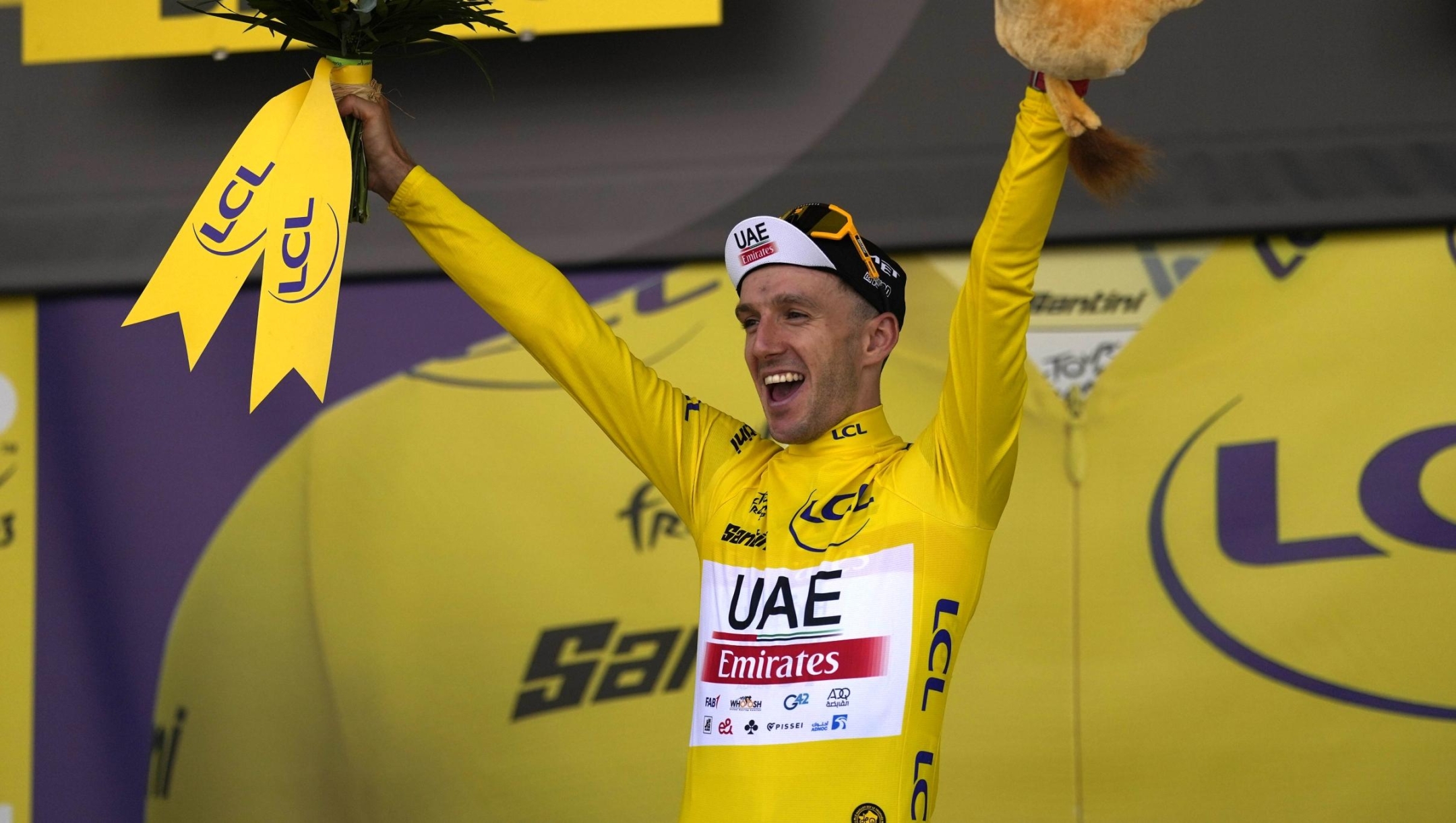 Britain's Adam Yates wearing the overall leader's yellow jersey, celebrates on the podium of the first stage of the Tour de France cycling race over 182 kilometers (113 miles) with start and finish in Bilbao, Spain, Saturday, July 1, 2023. (AP Photo/Thibault Camus)