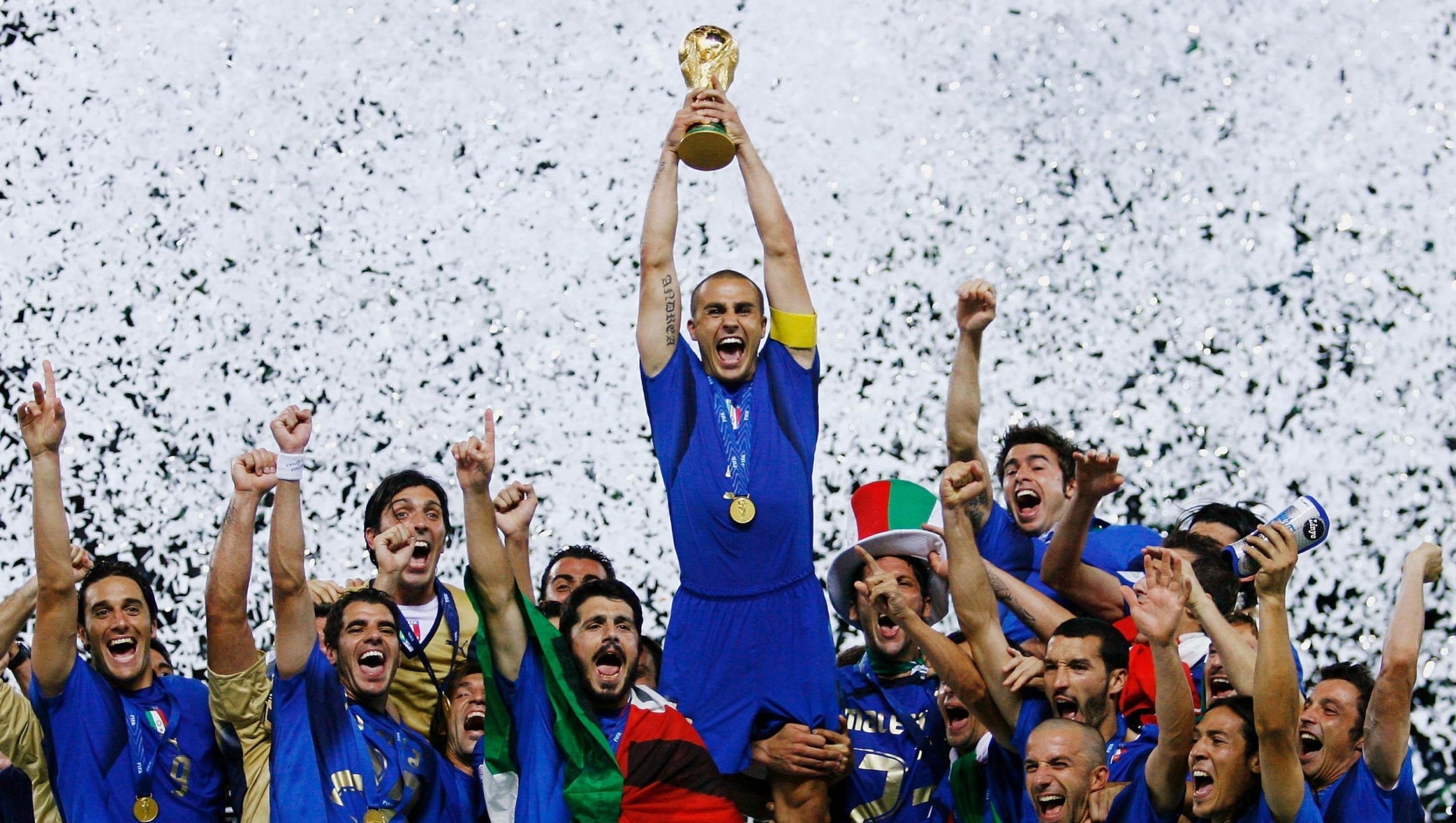 BERLIN - JULY 09:  The Italian players celebrate as Fabio Cannavaro of Italy lifts the World Cup trophy aloft following victory in a penalty shootout at the end of the FIFA World Cup Germany 2006 Final match between Italy and France at the Olympic Stadium on July 9, 2006 in Berlin, Germany.  (Photo by Shaun Botterill/Getty Images)