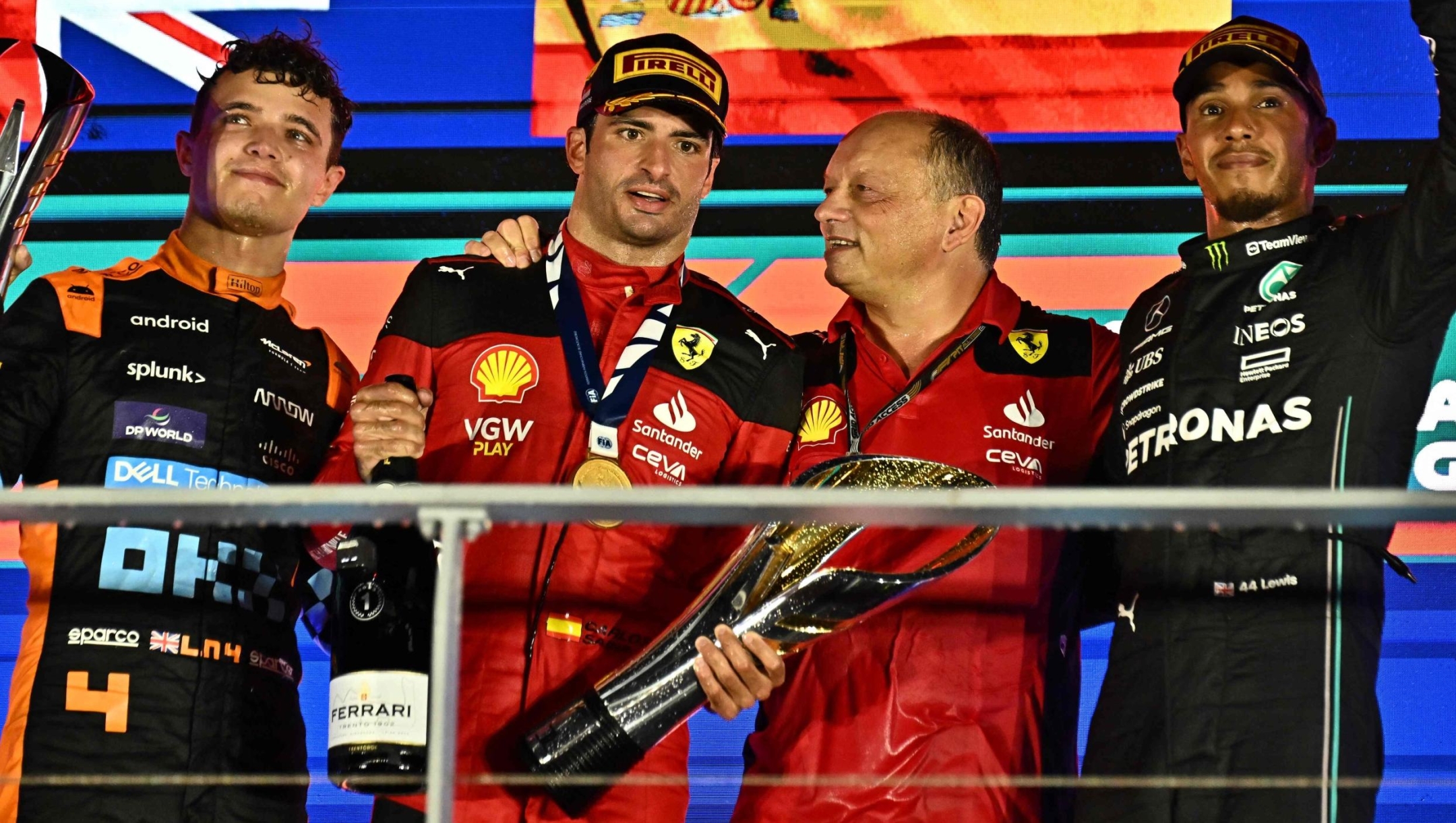 Ferrari's Spanish driver Carlos Sainz Jr (2nd L) celebrates on the podium with Ferrari team principal Frederic Vasseur (2nd R) after winning the Singapore Formula One Grand Prix night race, with McLaren's British driver Lando Norris (L) who finished second and Mercedes' British driver Lewis Hamilton who finished third (R), at the Marina Bay Street Circuit in Singapore on September 17, 2023. (Photo by Lillian SUWANRUMPHA / AFP)