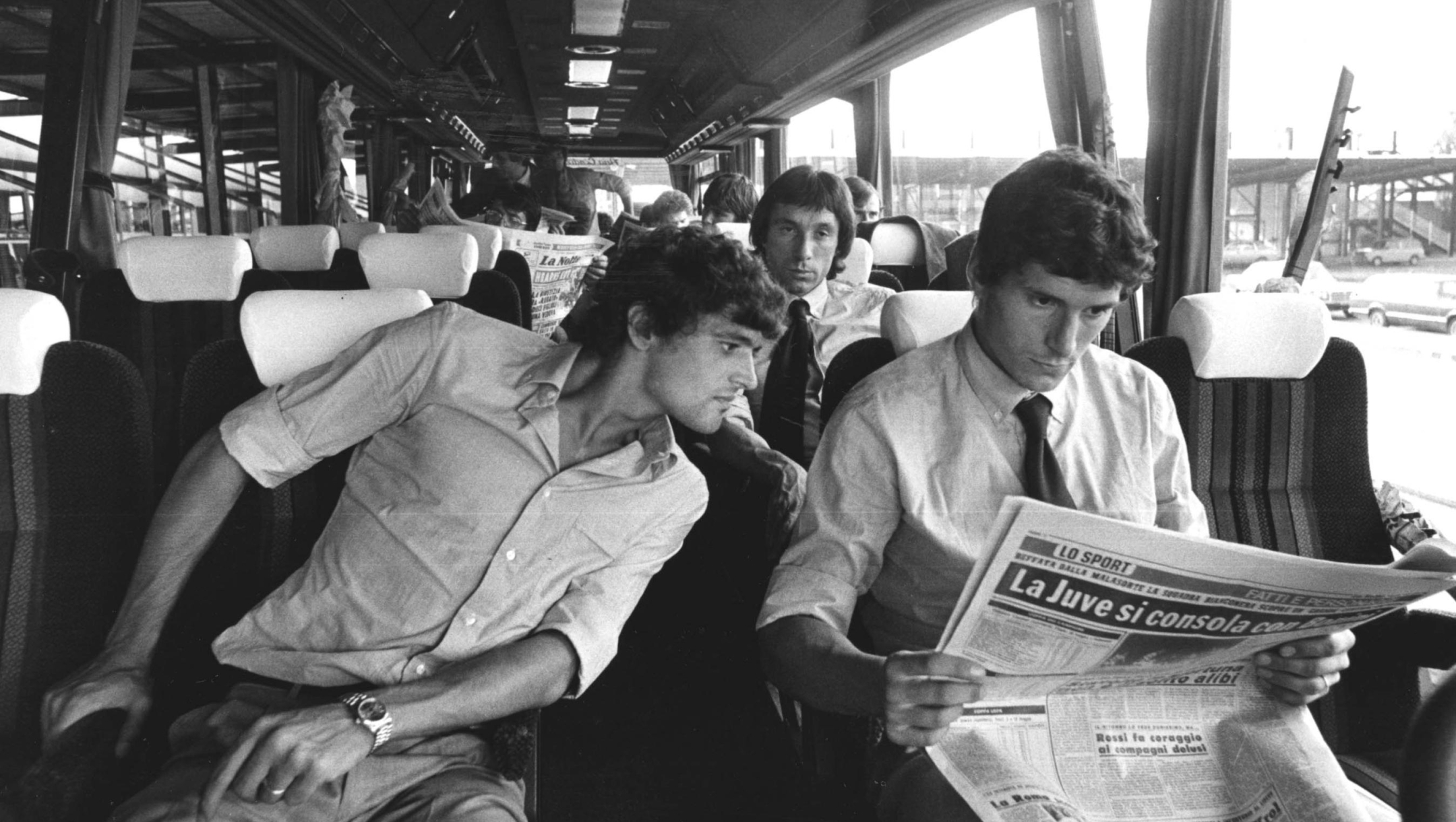 STAGIONE 1981/82. I GIOCATORI DELL'INTER IN PARTENZA PER UNA TRASFERTA CON IL PULLMAN. ALESSANDRO ALTOBELLI LEGGE IL GIORNALE DI GIANCARLO PASINATO. DIETRO DI LORO GIAMPIERO MARINI