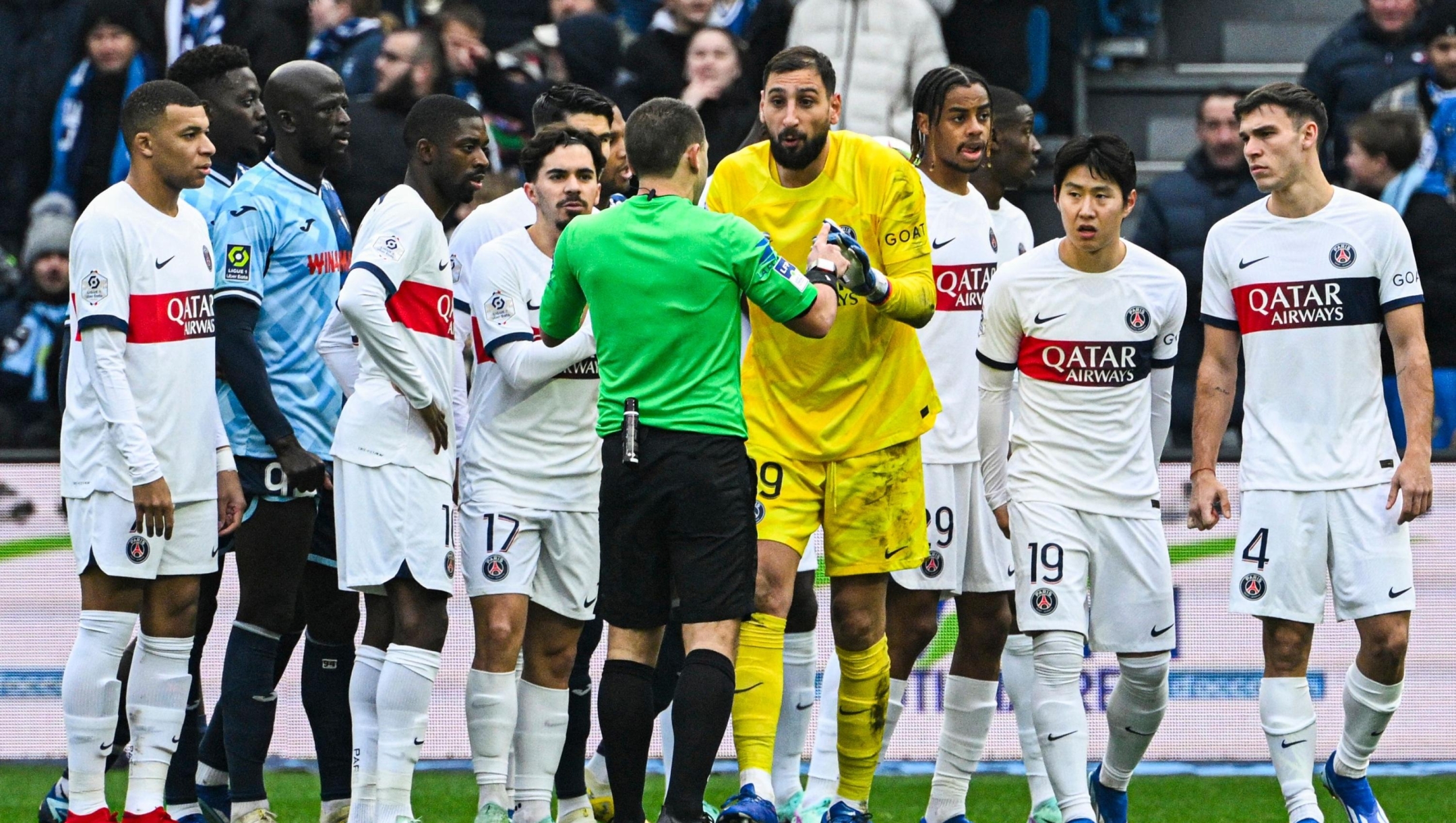 French referee Bastien Dechepy (C) prepares to give a red card to Paris Saint-Germain's Italian goalkeeper #99 Gianluigi Donnarumma (4thR) during the French L1 football match between Le Havre AC and Paris Saint-Germain (PSG) at The Stade Oceane in Le Havre, north-western France, on December 3, 2023. (Photo by DAMIEN MEYER / AFP)