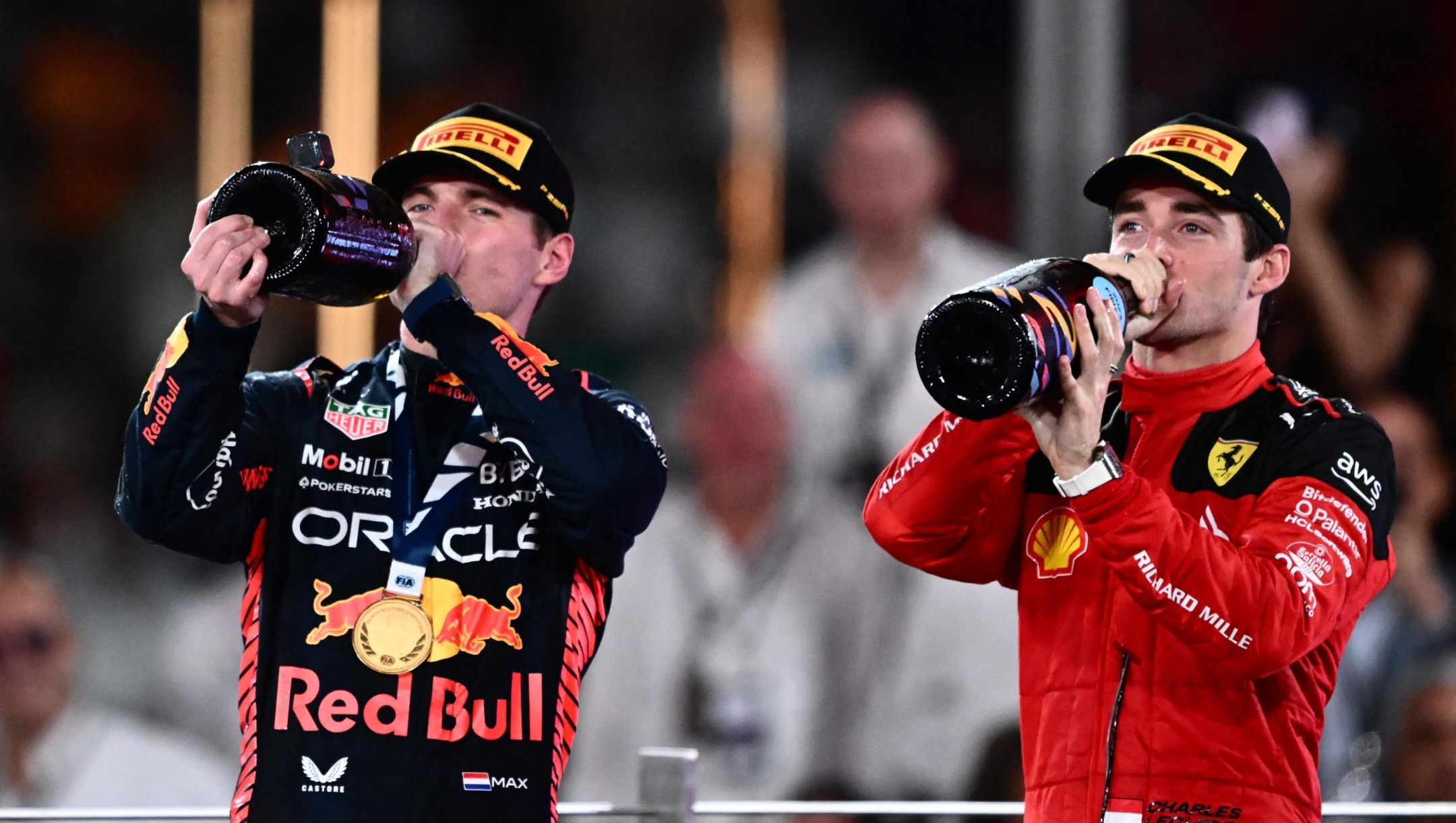 Red Bull Racing's Dutch driver Max Verstappen and Ferrari's Monegasque driver Charles Leclerc celebrate on the podium after the Abu Dhabi Formula One Grand Prix at the Yas Marina Circuit in the Emirati city on November 26, 2023. (Photo by Jewel SAMAD / AFP)