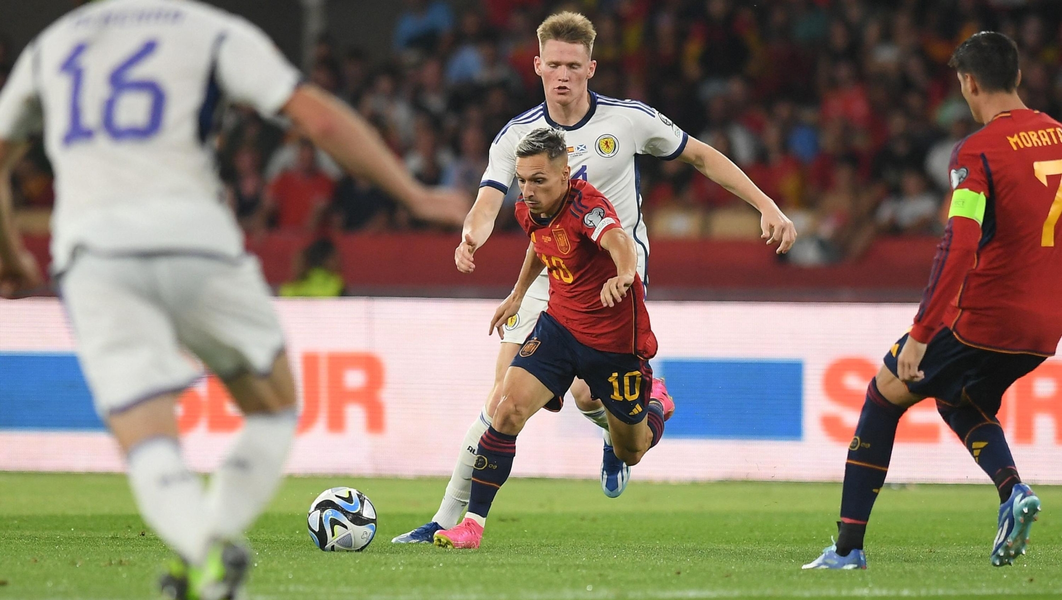 Spain's forward #10 Bryan Zaragoza vies with Scotland's midfielder #04 Scott McTominay during the EURO 2024 first round group A qualifying football match between Spain and Scotland at the La Cartuja stadium in Seville on October 12, 2023. (Photo by JORGE GUERRERO / AFP)