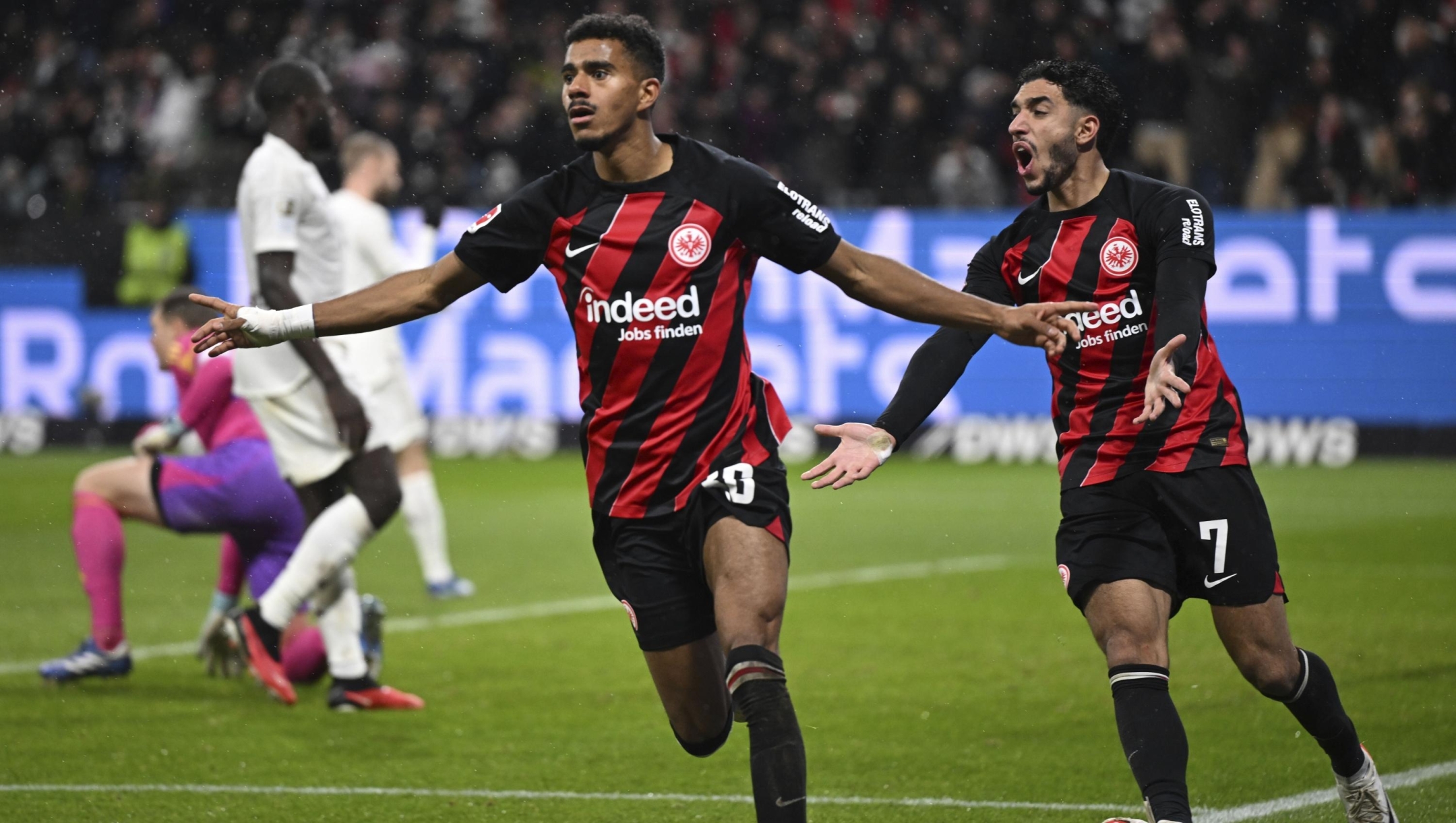 Frankfurt's Ansgar Knauff, left, and Omar Marmoush celebrate their victory during the German Bundesliga soccer match between Eintracht Frankfurt and Bayern Munich at Deutsche Bank Park in Frankfurt, Germany, Saturday, Dec. 9, 2023. (Arne Dedert/dpa via AP)