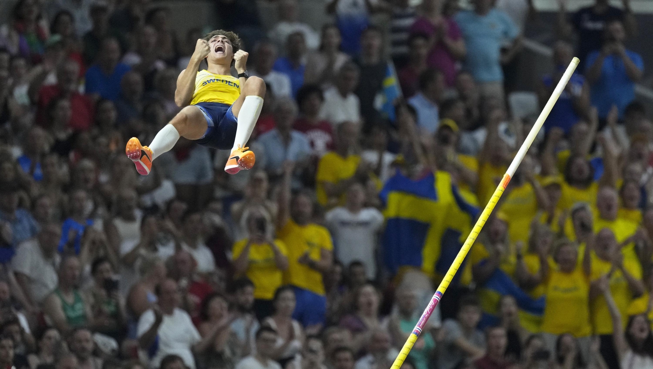 Fabs on the stands cheer as Armand Duplantis, of Sweden, reacts after a successful attempt in the Men's pole vault final during the World Athletics Championships in Budapest, Hungary, Saturday, Aug. 26, 2023. (AP Photo/Bernat Armangue)