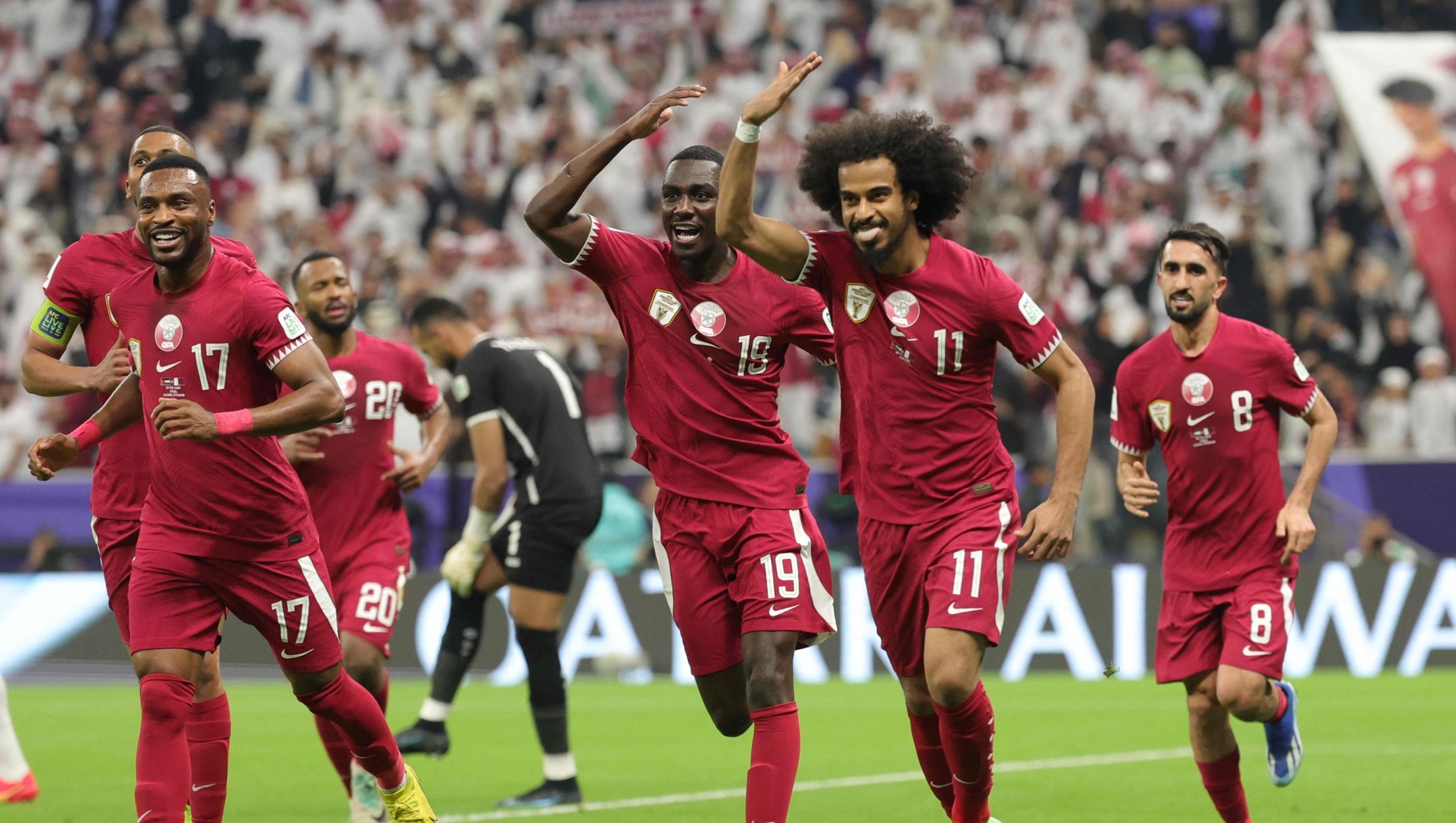 TOPSHOT - Qatar's forward #11 Akram Afif celebrates with teammates after scoring his second goal from a penalty shot during the AFC Qatar 2023 Asian Cup final football match between Jordan and Qatar at the Lusail Stadium in Lusail, north of Doha on February 10, 2024. (Photo by Giuseppe CACACE / AFP)