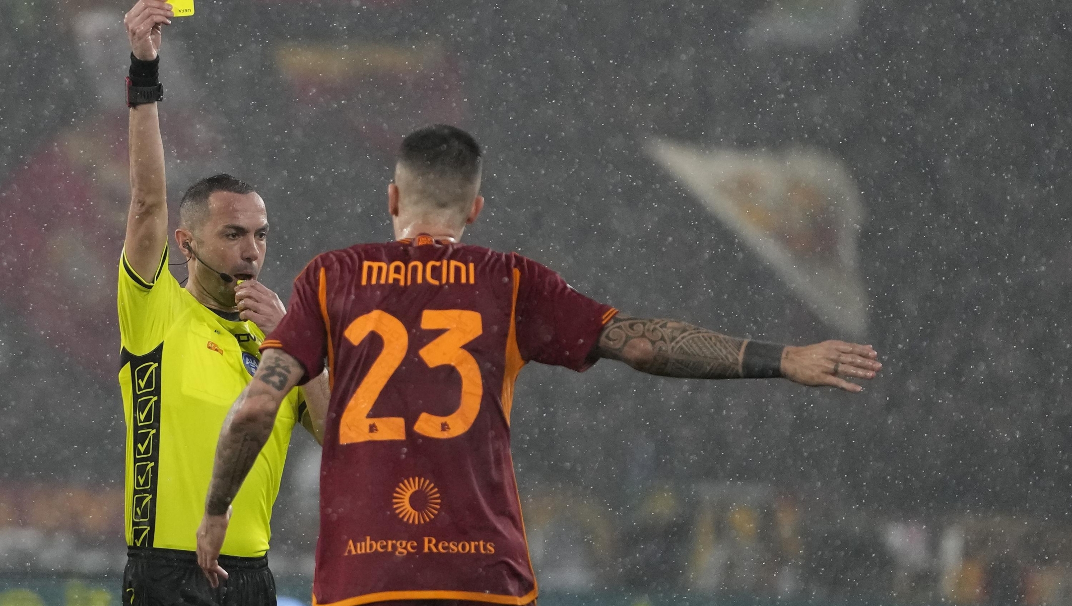 Referee Marco Guida shows the yellow card to Roma's Gianluca Mancini during the Italian Serie A soccer match between Roma and Inter Milan at Rome's Olympic stadium, Saturday, Feb. 10, 2024. (AP Photo/Alessandra Tarantino)