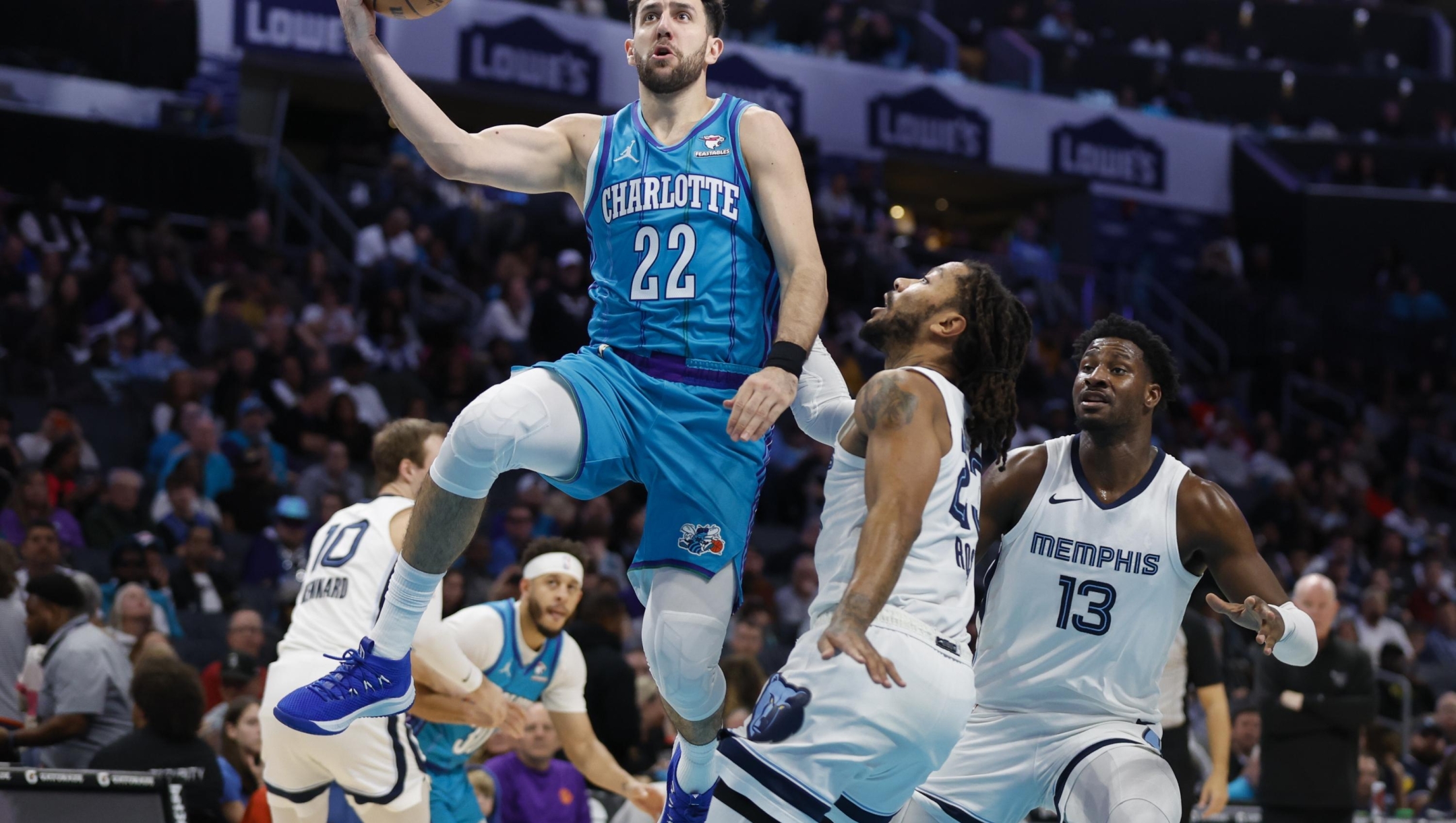 Charlotte Hornets guard Vasilije Micic (22) shoots against Memphis Grizzlies guard Derrick Rose, center, as forward Jaren Jackson Jr. (13) watches during the second half of an NBA basketball game in Charlotte, N.C., Saturday, Feb. 10, 2024. (AP Photo/Nell Redmond)