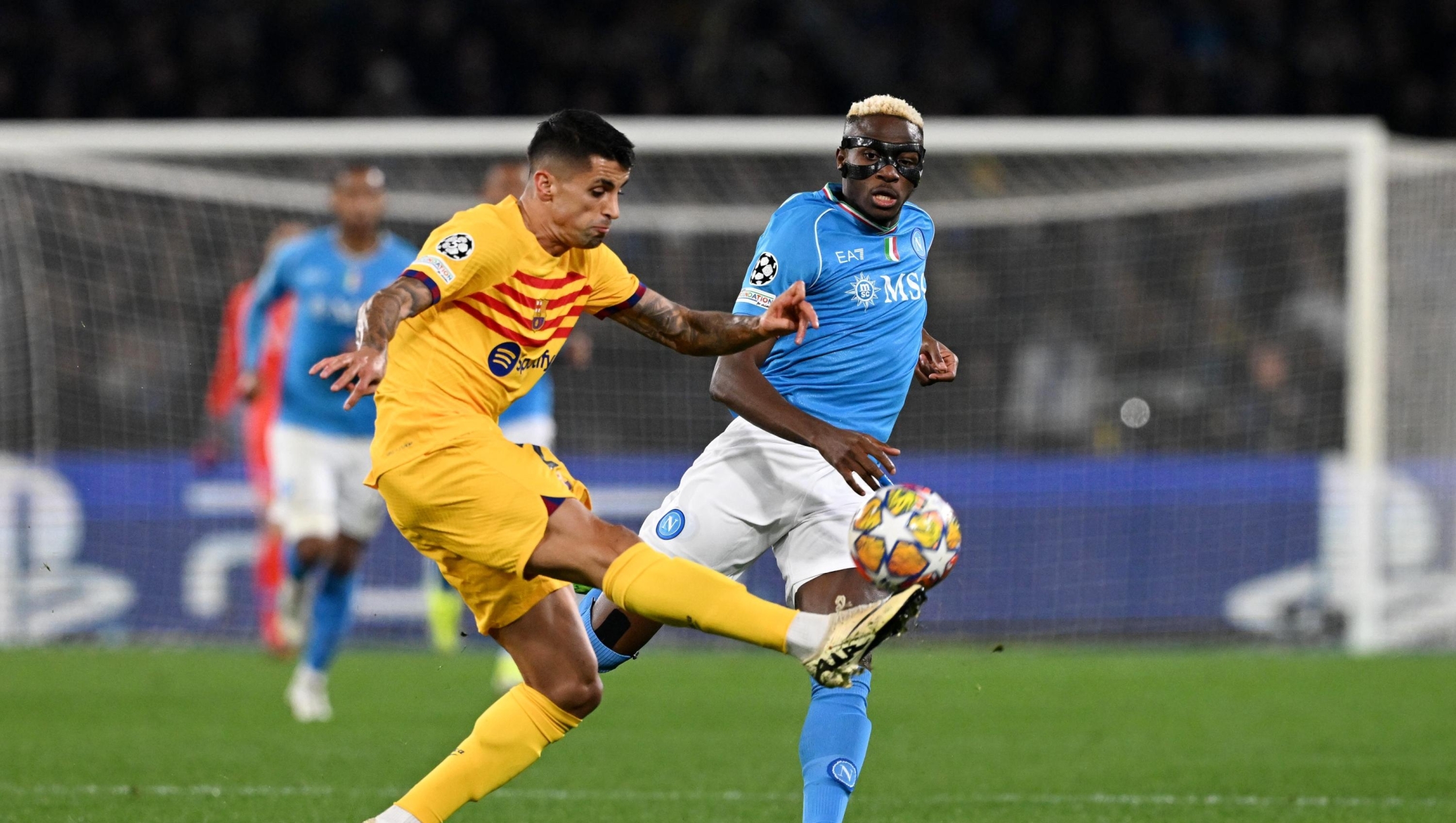NAPLES, ITALY - FEBRUARY 21: Joao Cancelo of FC Barcelona clears the ball whilst under pressure from Victor Osimhen of SSC Napoli during the UEFA Champions League 2023/24 round of 16 first leg match between SSC Napoli and FC Barcelona at Stadio Diego Armando Maradona on February 21, 2024 in Naples, Italy. (Photo by Francesco Pecoraro/Getty Images)