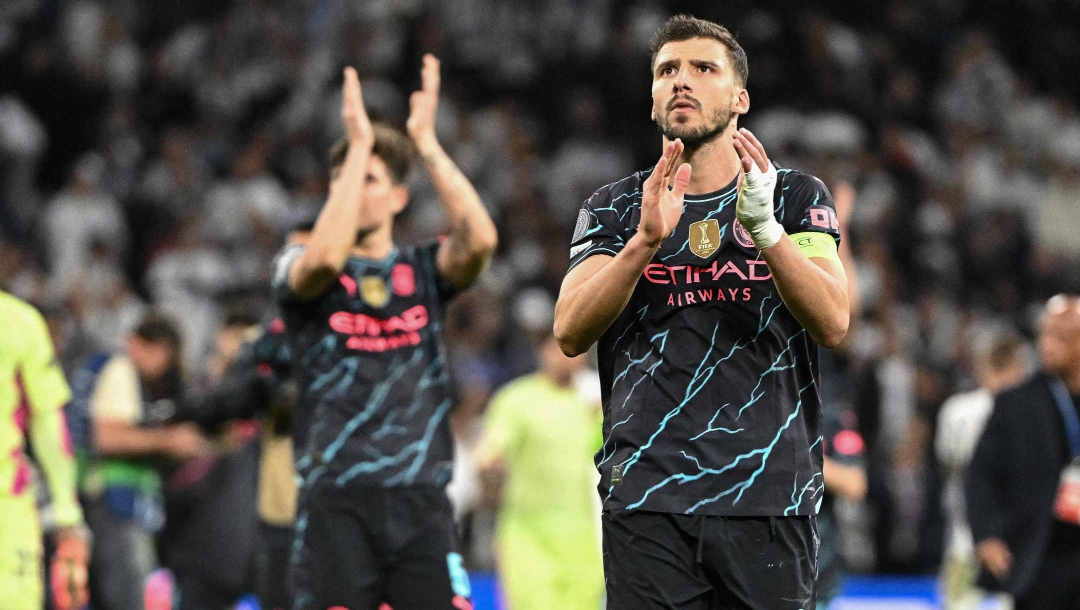 Manchester City's Portuguese defender #03 Ruben Dias and teammates applaud at the end of the UEFA Champions League quarter final first leg football match between Real Madrid CF and Manchester City at the Santiago Bernabeu stadium in Madrid on April 9, 2024. The match ended in a 3-3 draw. (Photo by JAVIER SORIANO / AFP)