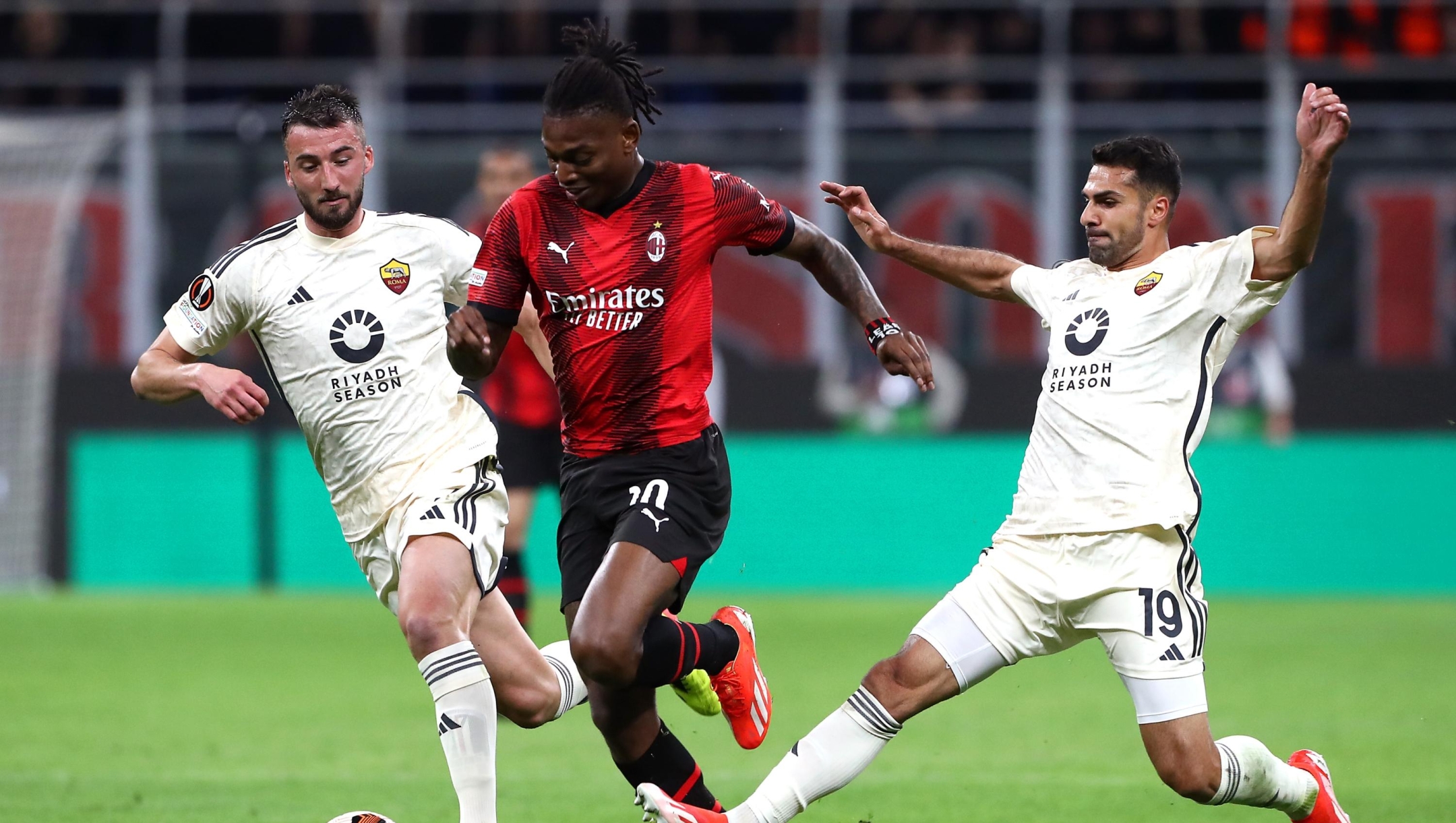 MILAN, ITALY - APRIL 11: Rafael Leao of AC Milan battles for possession with Bryan Cristante and Zeki Celik of AS Roma during the UEFA Europa League 2023/24 Quarter-Final first leg match between AC Milan and AS Roma at Stadio Giuseppe Meazza on April 11, 2024 in Milan, Italy. (Photo by Marco Luzzani/Getty Images)