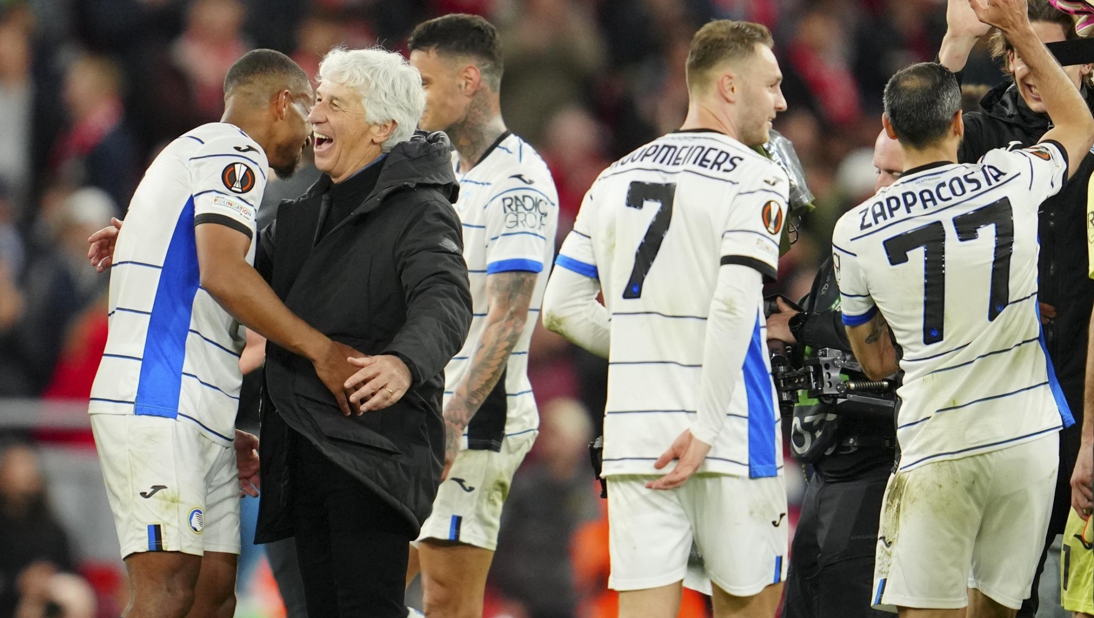 Atalanta's head coach Gian Piero Gasperini, third from left, celebrates with his players at the end of the Europa League quarter final first leg soccer match between Liverpool and Atalanta, at the Anfield stadium in Liverpool, England, Thursday, April 11, 2024. Atalanta won 3-0. (AP Photo/Jon Super)
