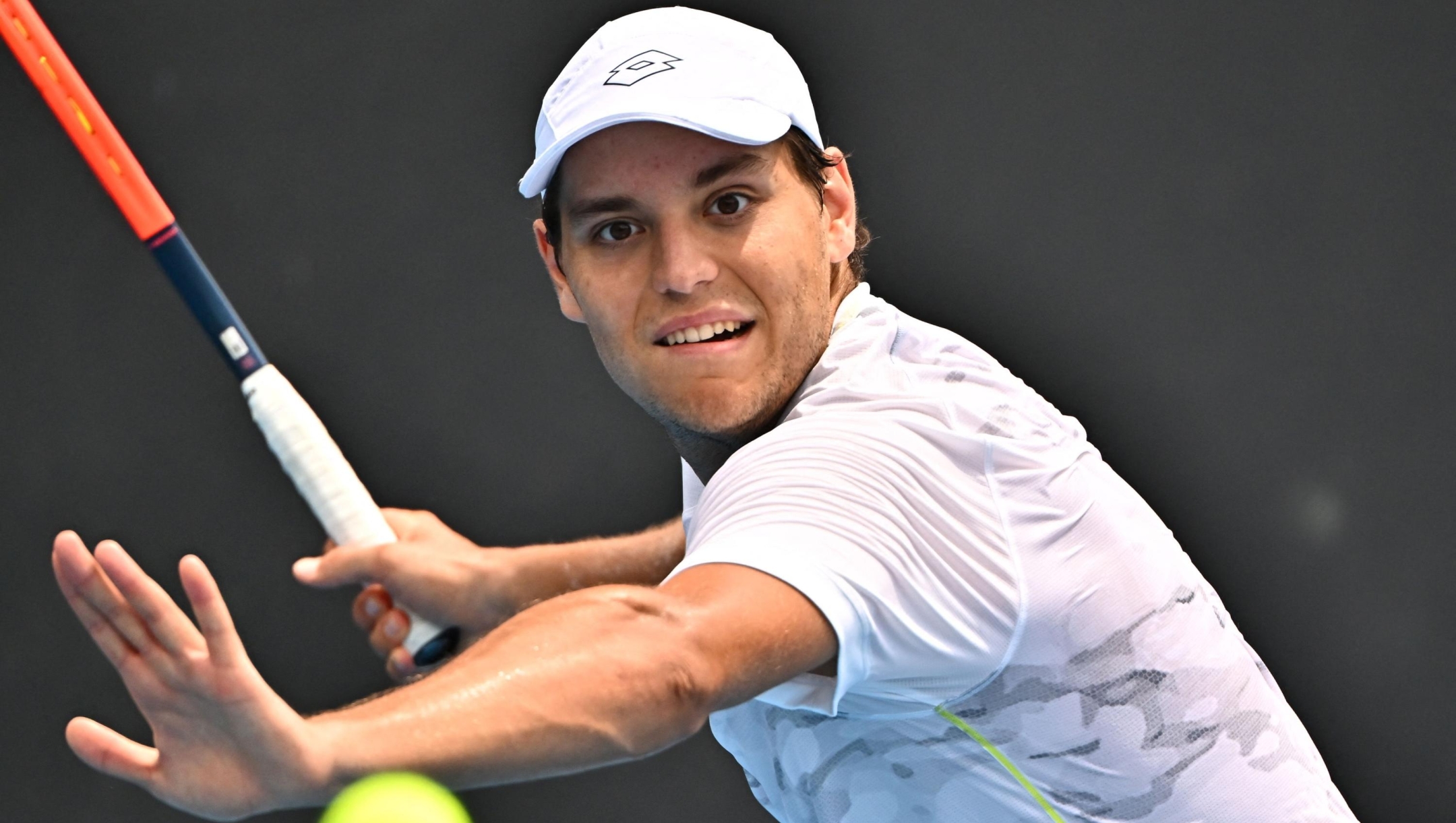 Russia's Pavel Kotov hits a return against France's Arthur Rinderknech during their men's singles match on day one of the Australian Open tennis tournament in Melbourne on January 14, 2024. (Photo by Lillian SUWANRUMPHA / AFP) / -- IMAGE RESTRICTED TO EDITORIAL USE - STRICTLY NO COMMERCIAL USE --