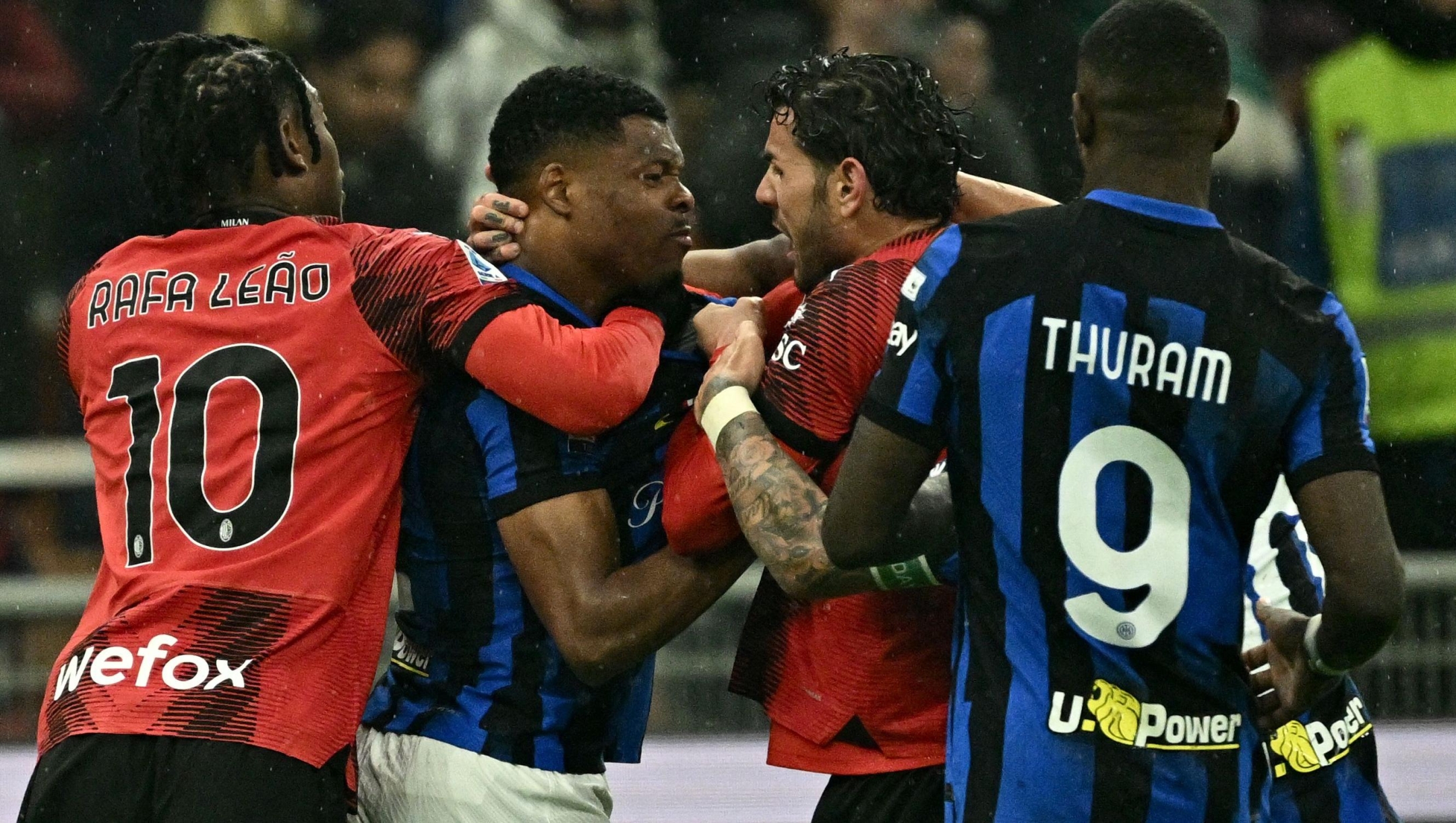 AC Milan's French defender #19 Theo Hernandez (C-R)) fights with Inter Milan's Dutch defender #02 Denzel Dumfries (2C-L) during the Italian Serie A football match between AC Milan and Inter Milan at the San Siro Stadium in Milan on April 22, 2024. (Photo by GABRIEL BOUYS / AFP)