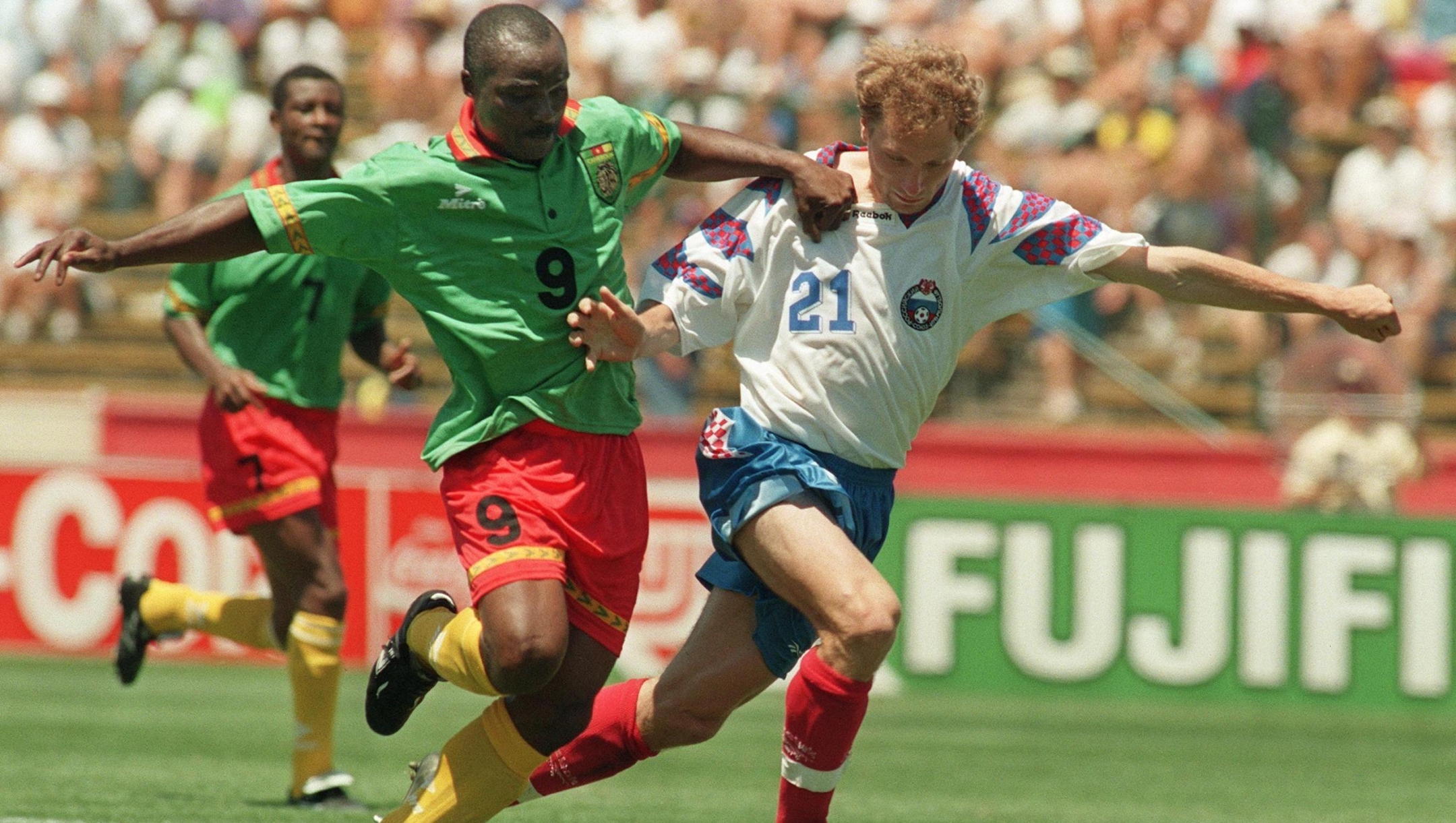 Cameroon's forward Roger Milla (L) runs past Russia's Dimitri Khlestov on his way to score a goal 28 June 1994 at Stanford stadium in San Francisco during their Soccer World Cup match. At age 42, Roger Milla became the oldest player ever to score a goal in World Cup history, but could not help his team as Russia won 6-1 with forward Oleg Salenko, scoring a record 5 goals. AFP PHOTO/ANTONIO SCORZA