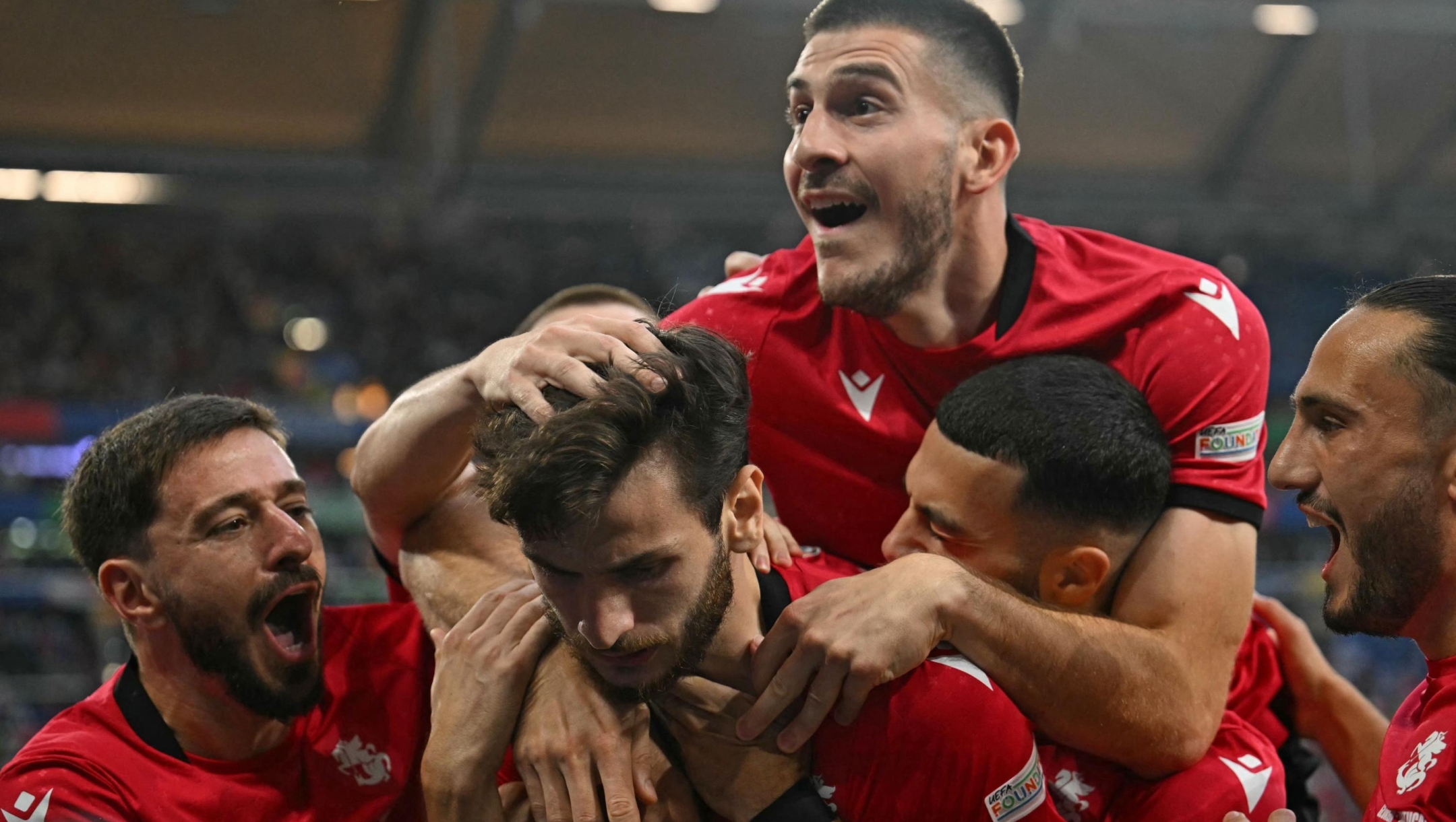 Georgia's forward #07 Khvicha Kvaratskhelia celebrates scoring his team's first goal with his team mates during the UEFA Euro 2024 Group F football match between Georgia and Portugal at the Arena AufSchalke in Gelsenkirchen on June 26, 2024. (Photo by OZAN KOSE / AFP)