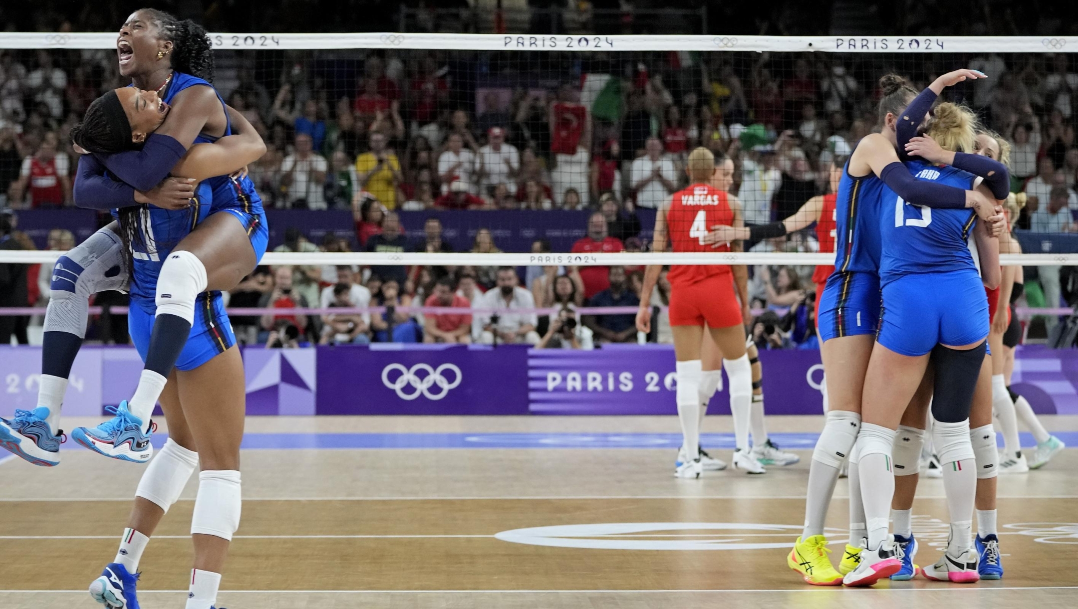 Italy's Myriam Sylla, top left, and Italy's Oghosasere Omoruyi celebrate their win over Turkey in a semifinal women's volleyball match at the 2024 Summer Olympics, Thursday, Aug. 8, 2024, in Paris, France. (AP Photo/Dolores Ochoa)