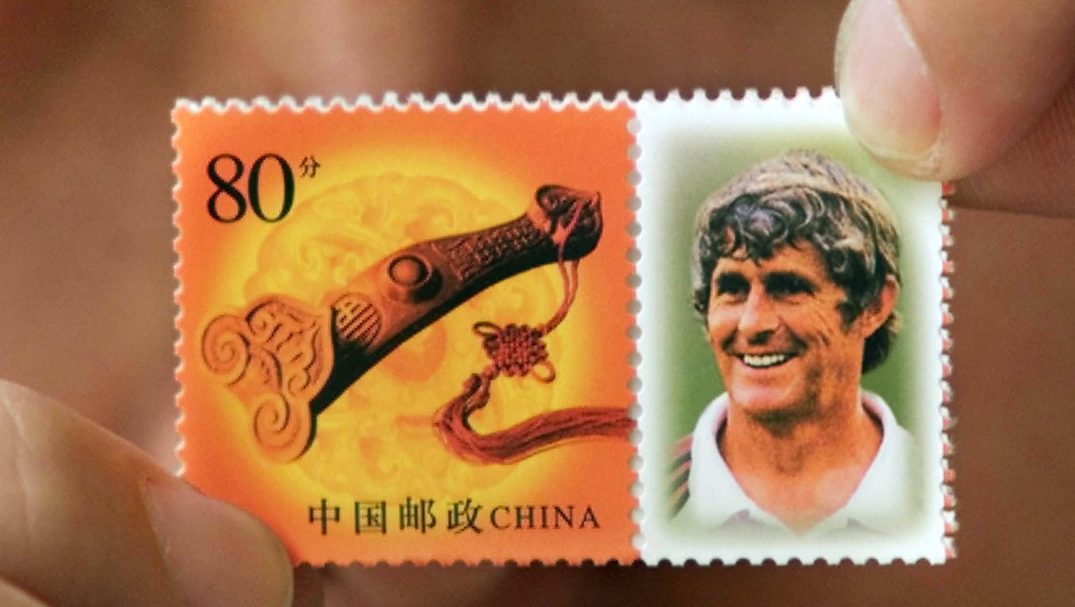 A Chinese man shows a commemorative stamp featuring Bora Milutinovic, the coach of the Chinese soccer team, at a post office in Beijing Monday, May 27, 2002. The set, which sells for 150 Yuan (US$18.15), was issued Monday, four days before the opening of the World Cup finals in which China will compete for the first time ever. Milutinovic, known locally as "Milu" is revered in China for coaching China to the finals for the first time. (AP Photo/Vincent Thian)