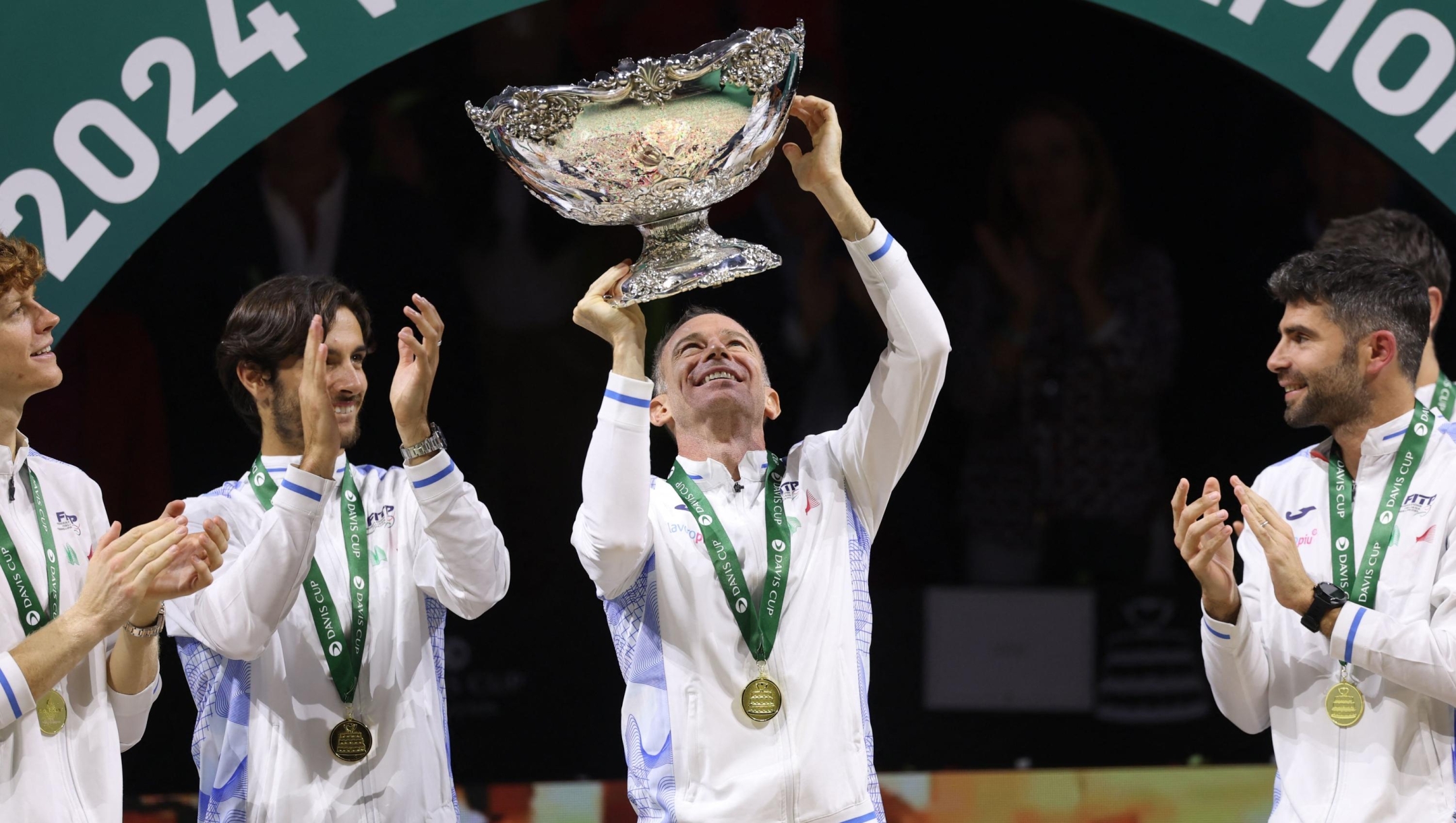 Italy's captain Filippo Volandri raises the trophy with teammates after winning the Davis Cup Finals at the Palacio de Deportes Jose Maria Martin Carpena arena in Malaga, southern Spain, on November 24, 2024. (Photo by Thomas COEX / AFP)