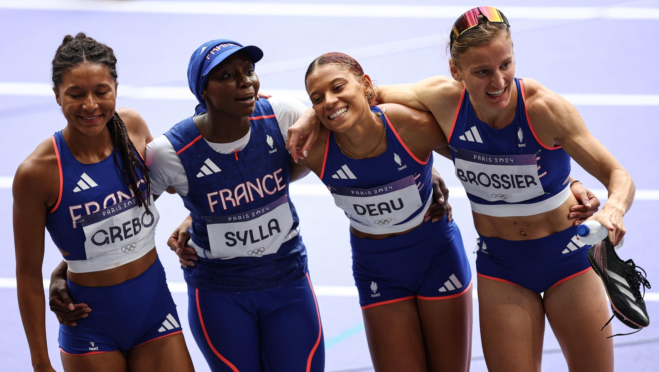 France's Shana Grebo, Sounkamba Sylla, Alexe Deau and Amandine Brossier celebrate after competing in the women's 4x400m relay heat of the athletics event at the Paris 2024 Olympic Games at Stade de France in Saint-Denis, north of Paris, on August 9, 2024. (Photo by Anne-Christine POUJOULAT / AFP)