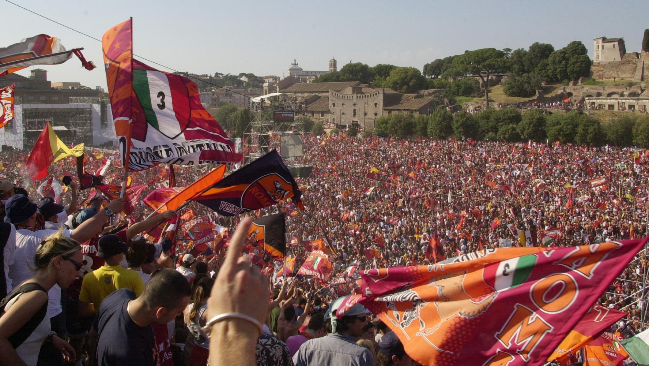 AS Roma soccer club supporters wave their flags and banners for the 7th straight day of celebrations since their team's championship win, at the culminating celebration concert by Roman singer and songwriter Antonello Venditti in Rome's historic Circus Maximus, Sunday June 24, 2001. Authorities said nearly one million people were gathering for the concert. (AP Photo/ Corrado Giambalvo)
