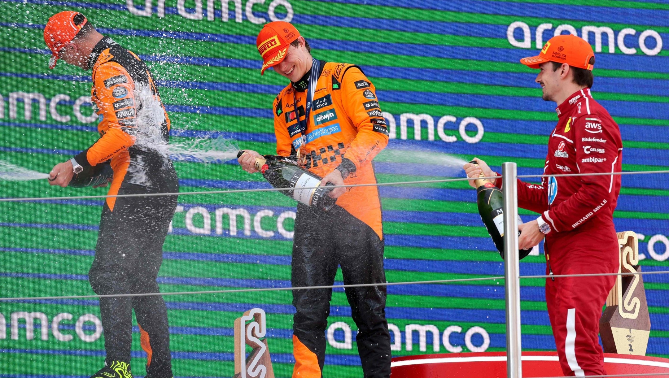 McLaren's British driver Lando Norris (L), McLaren's Australian driver Oscar Piastri (C) and Ferrari's Monegasque driver Charles Leclerc celebrate on the podium after the Formula One Spanish Grand Prix at the Circuit de Catalunya in Montmelo, on the outskirts of Barcelona, on June 1, 2025. (Photo by LLUIS GENE / AFP)