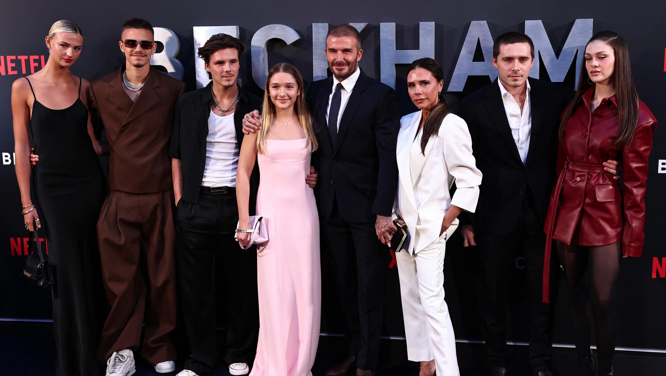 Former England footballer David Beckham (5L) and his wife Victoria Beckham (3R) pose on the red carpet with their children, and partners, (from L) Mia Regan, Romeo Beckham, Cruz Beckham, Harper Beckham, Brooklyn Beckham and Nicola Peltz Beckham upon arrival to attend the Premiere of "Beckham" in London on October 3, 2023. (Photo by HENRY NICHOLLS / AFP)
