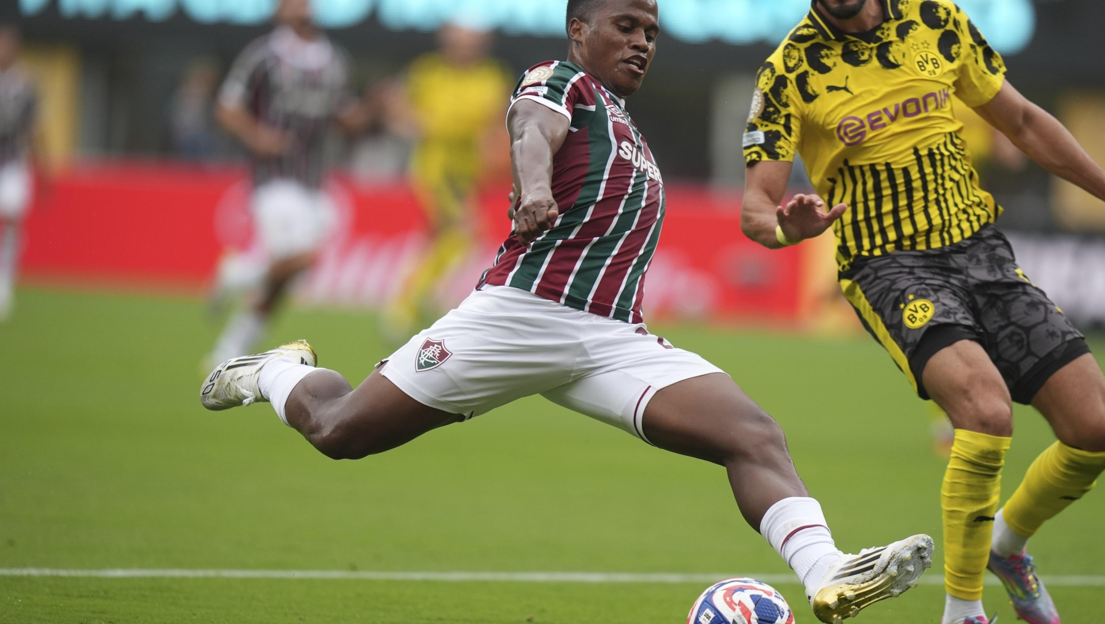 Fluminense's Jhon Arias takes a shot challenged by Borussia Dortmund's Ramy Bensebaini during the Club World Cup group F soccer match between Fluminense and Borussia Dortmund in East Rutherford, N.J., Tuesday, June 17, 2025. (AP Photo/Frank Franklin II)