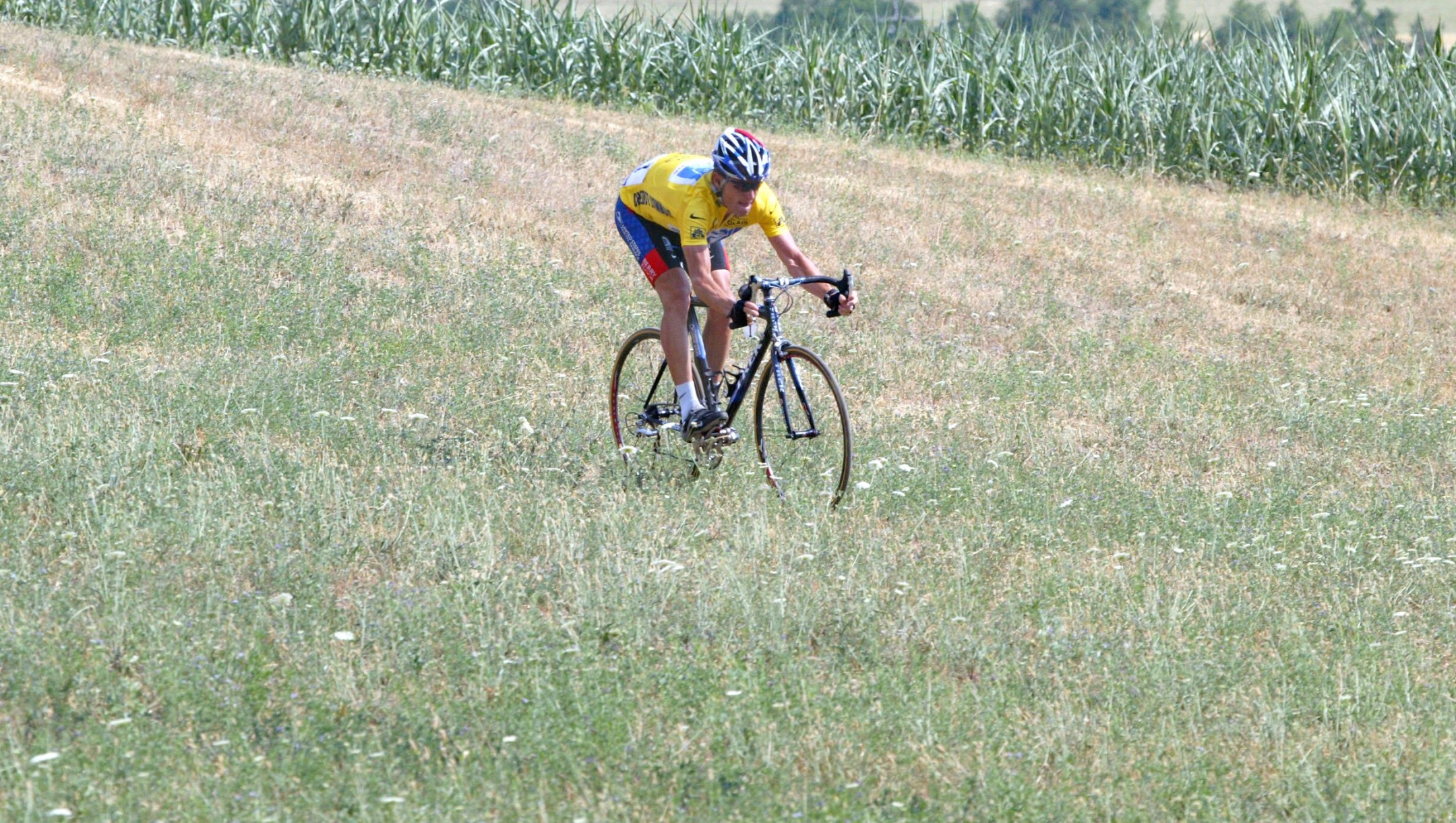 US Lance Armstrong (US Postal/USA) rides on the grass after avoiding Spaniard Joseba Beloki (ONCE/Spa) who fell down at the end of the ninth stage of the 90th Tour de France cycling race between Bourg d'Oisans and Gap, 14 July 2003. AFP PHOTO JOEL SAGET (Photo by JOEL SAGET / AFP)