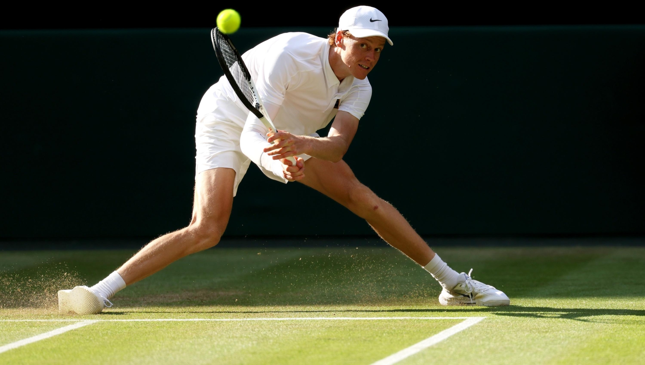 Jannik Sinner of Italy slides to play a backhand against Carlos Alcaraz of Spain during the Gentleman's Singles Final on day fourteen of The Championships Wimbledon 2025 at All England Lawn Tennis and Croquet Club on July 13, 2025 in London, England. (Photo by Clive Brunskill/Getty Images)